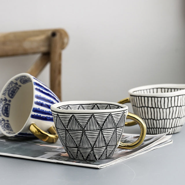 Junips | Cup with abstract geometric pattern and gold handle