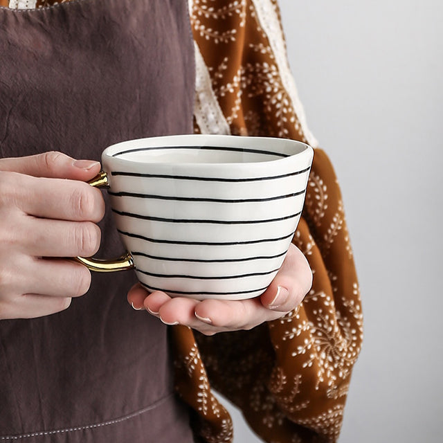 Junips | Cup with abstract geometric pattern and gold handle
